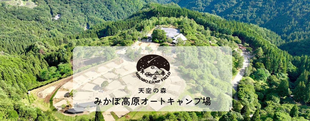 ドローンで上空から撮影した山の緑に囲まれたキャンプ場