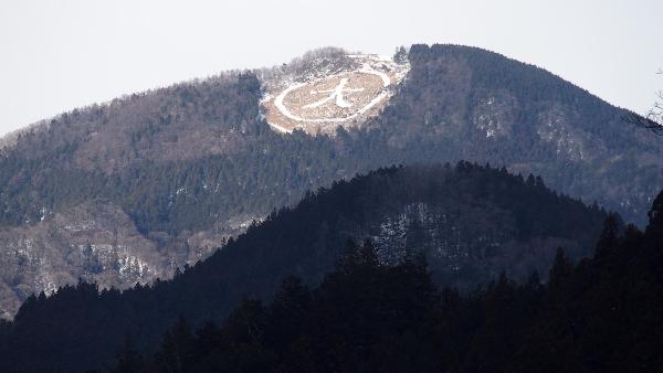 山の面に雪が積もり駆り出されたまるだい（丸の中に大の文字）がくっきりと浮かび上がっている